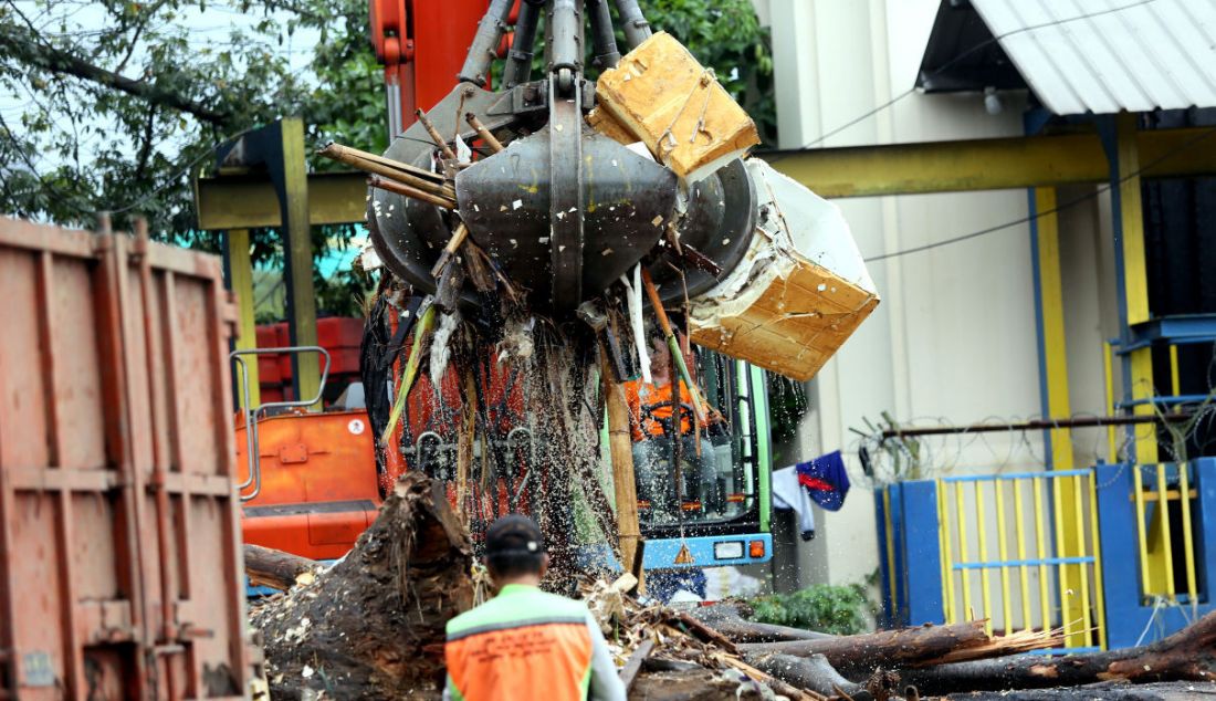 Petugas saat mengangkut sampah dengan menggunakan alat berat di pintu air Manggarai, Jakarta, Sabtu (16/7). Hujan deras yang terjadi sejak Jumat (15/7) malam menyebabkan sampah terbawa dan memenuhi pintu air Manggarai. - JPNN.com