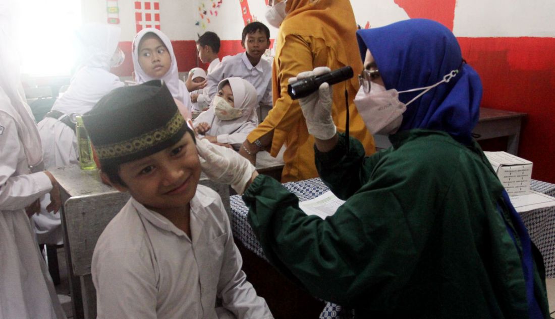 Paramedis Puskesmas Cinere memeriksa kesehatan murid kelas III di SDI Al Hidayah, Cinere, Depok, Senin (12/9). - JPNN.com