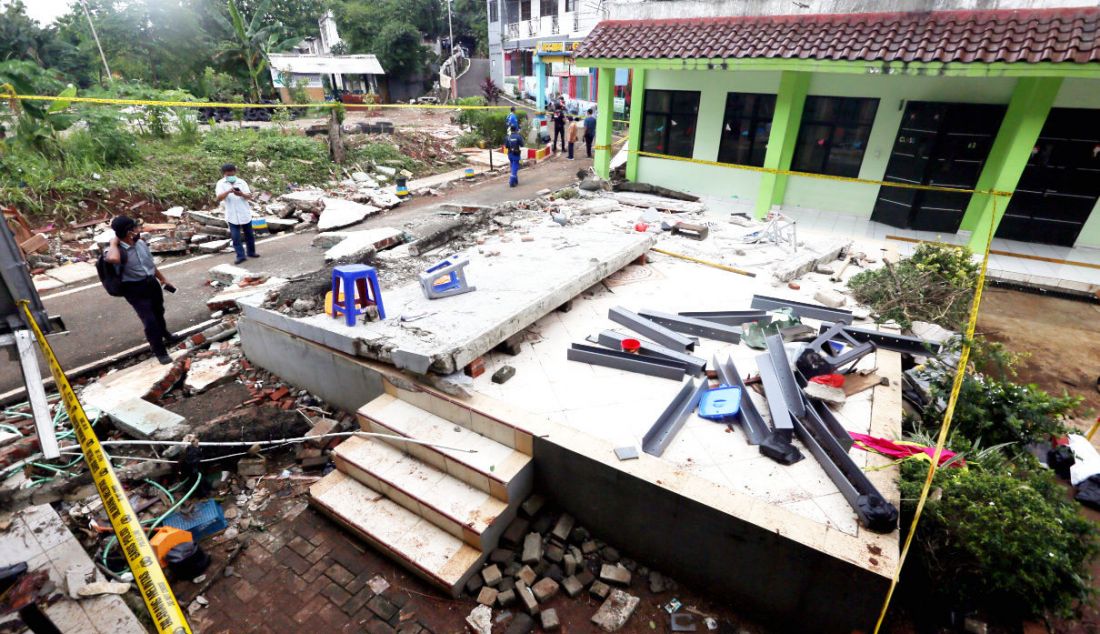 Garis polisi terpasang di tembok roboh MTsN 19 Pondok Labu, Jakarta, Jumat (7/10). Sebanyak tiga siswa meninggal tertimpa tembok yang roboh akibat terjangan banjir pada Kamis (6/10) sore. - JPNN.com