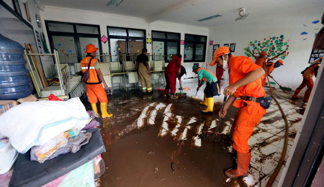 Petugas PPSU membersihkan ruang kelas yang terendam banjir di MTsN 19 Pondok Labu. Tiga siswa meninggal tertimpa tembok yang roboh akibat terjangan banjir di sekolah tersebut pada Kamis (6/10) sore. - JPNN.com