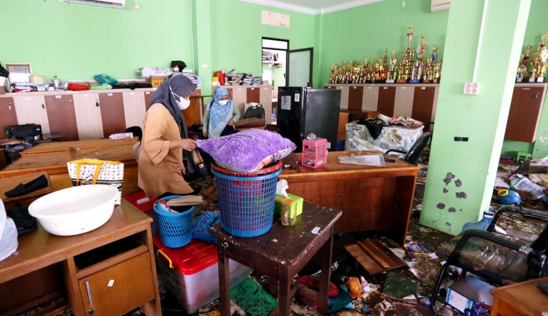 Sejumlah guru melihat kondisi ruangan MTsN 19 Jakarta di Pondok Labu, setelah diterjang banjir. Sebanyak tiga orang siswa meninggal tertimpa tembok yang roboh akibat terjangan banjir di sekolah tersebut pada Kamis (6/10) sore. - JPNN.com