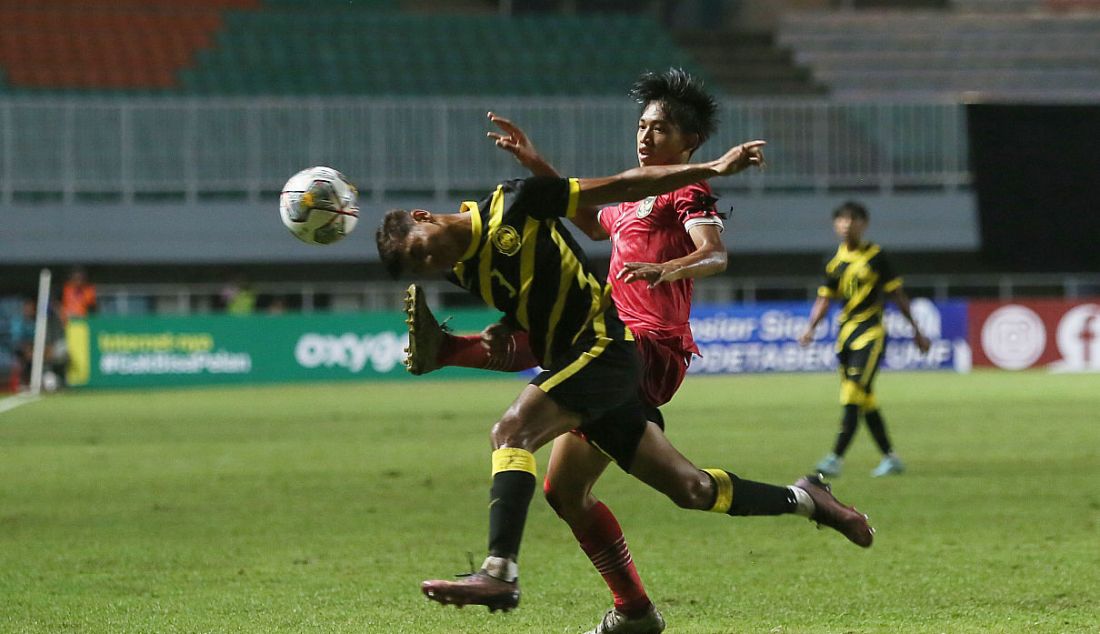 Pemain Timnas U-17 Indonesia Achmad Zidan Rosyid berduel dengan pemain Malaysia pada Kualifikasi Grup B Piala Asia U-17 di Stadion Pakansari, Kabupaten Bogor, Jawa Barat, Minggu (9/10). Indonesia kalah 1-5. - JPNN.com