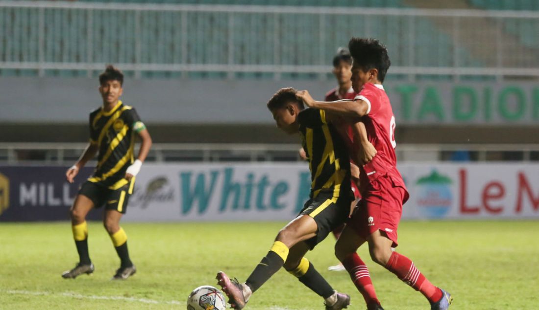 Pemain Timnas U-17 Indonesia Muhammad Kafiatur Rizky gagal merebut bola dari pemain Timnas U-17 Malaysia pada Kualifikasi Piala Asia U-17 di Stadion Pakansari, Kabupaten Bogor, Jawa Barat, Minggu (9/10). Timnas U-17 Indonesia kalah atas Timnas U-17 Malaysia dengan skor 1-5. - JPNN.com