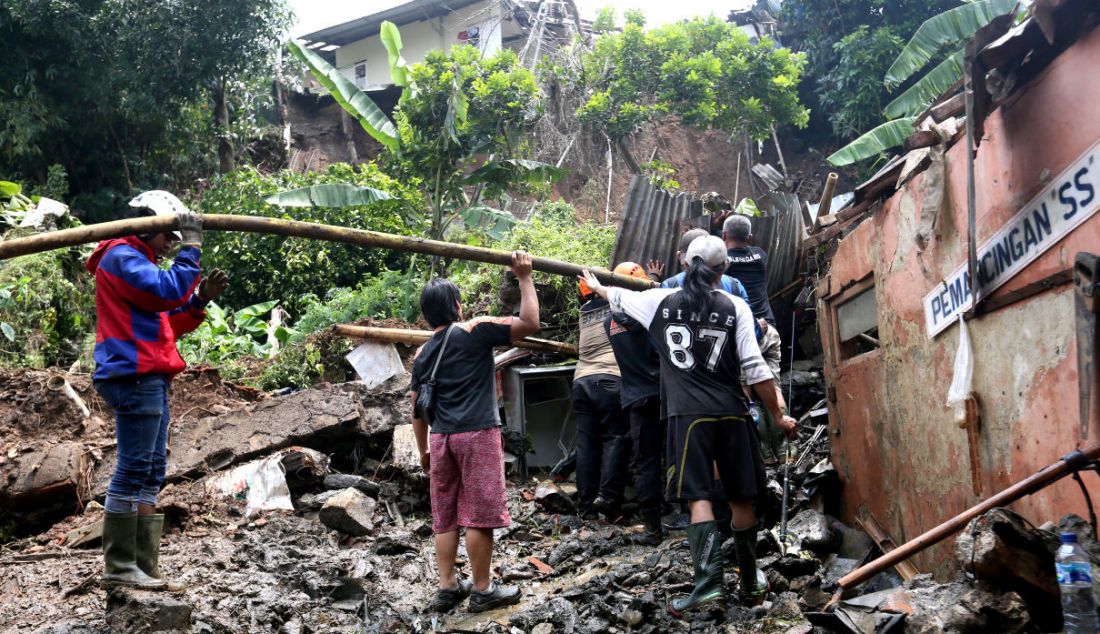 Petugas BPBD Kota Bogor bersama warga membersihkan tempat pemancingan yang longsor di Kelurahan Kebon Kelapa, Kota Bogor, Jawa Barat, Rabu (12/10). - JPNN.com