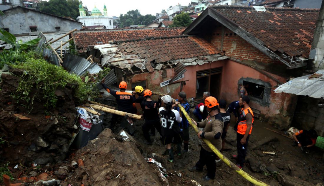 Petugas BPBD Kota Bogor bersama warga membersihkan tempat pemancingan yang longsor di Kelurahan Kebon Kelapa, Kota Bogor, Jawa Barat, Rabu (12/10). Konon satu orang tewas dalam musibah itu. - JPNN.com