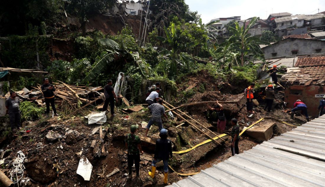 Petugas BPBD Kota Bogor bersama warga membersihkan tempat pemancingan yang longsor di Kelurahan Kebon Kelapa, Kota Bogor, Jawa Barat, Rabu (12/10). Konon satu orang tewas dalam musibah itu. - JPNN.com