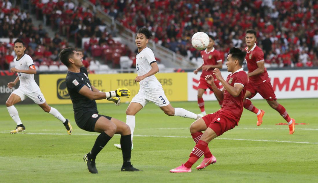 Pemain Indonesia Asnawi Mangkualam Bahar (kanan) saat berhadapan dengan kiper Kamboja pada AFF Cup 2022 di Stadion Utama Gelora Bung Karno, Jakarta, Jumat (23/12). Indonesia menang atas Kamboja dengan skor 2-1. - JPNN.com