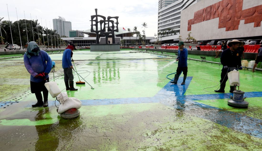 Pekerja membersihkan kolam air mancur di halaman depan Gedung Parlemen MPR/DPR-DPD, Senayan, Jakarta, Selasa (27/12). - JPNN.com