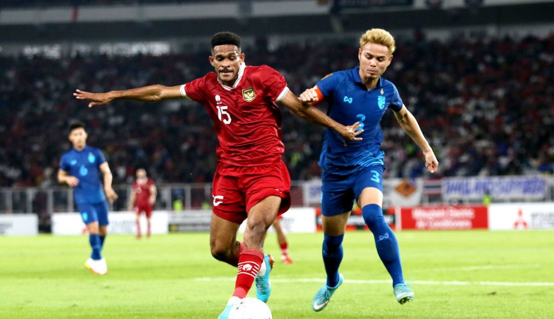 Pemain Timnas Indonesia Ricky Richardo Kambuaya (kiri) dikawal pemain Thailand Theerathon Bummathan dalam laga penyisihan Grup A Piala AFF 2022. Kedua negara berbagi gol, 1-1 dalam dua kali 45 menit. - JPNN.com