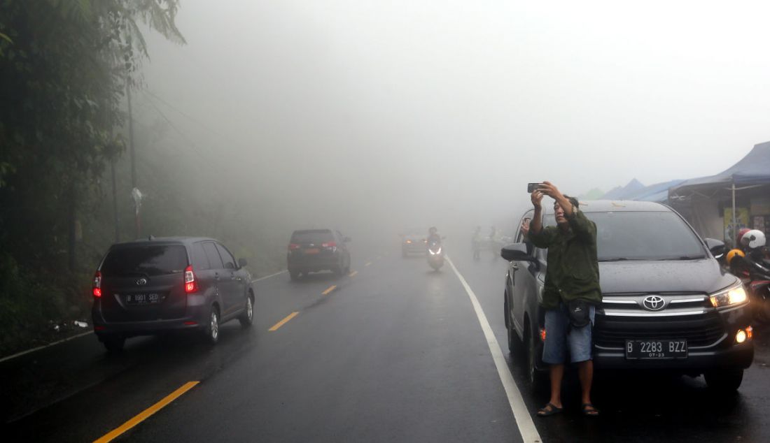 Sejumlah pengguna jalan saat melintasi kabut tebal di Puncak, Kabupaten Bogor, Jawa Barat, Sabtu (31/12). Menjelang malam pergantian tahun, hujan menguyur Puncak dan sekitarnya. - JPNN.com