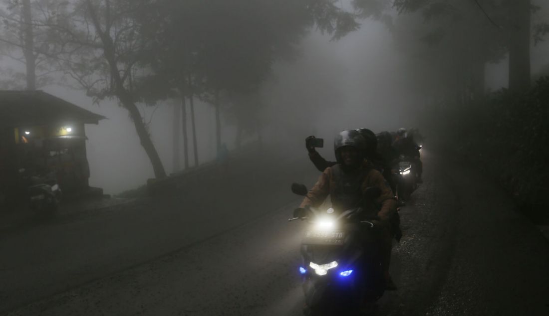 Sejumlah pengguna jalan saat melintasi kabut tebal di Puncak, Kabupaten Bogor, Jawa Barat, Sabtu (31/12). Menjelang malam pergantian tahun, hujan menguyur Puncak dan sekitarnya. - JPNN.com