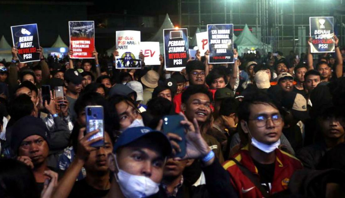 Penonton membentangkan spanduk dan poster dukungan terhadap pengusutan tragedi Kanjuruhan di konser amal serta doa bersama untuk para korban tragedi Kanjuruhan bertajuk 