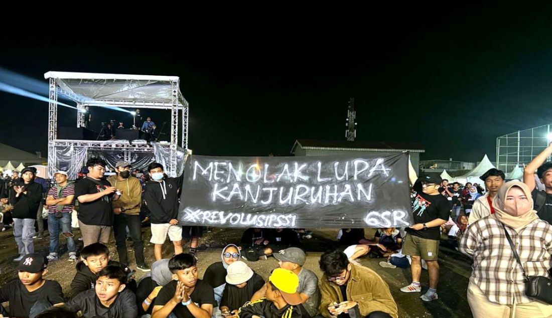 Penonton membentangkan spanduk dan poster dukungan terhadap pengusutan tragedi Kanjuruhan di konser amal serta doa bersama untuk para korban tragedi Kanjuruhan bertajuk 