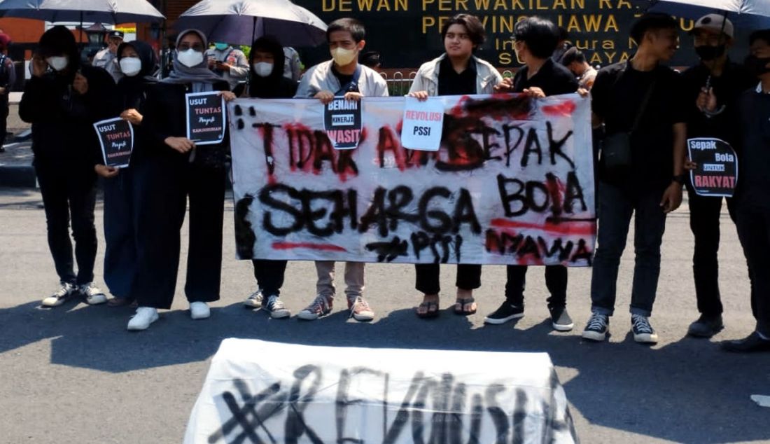 Puluhan suporter Persebaya Surabaya yang tergabung dalam Gerakan Sepak Bola untuk Rakyat (GSR) melakukan Aksi Menolak Lupa Tragedi Kanjuruhan di depan kantor DPRD Provinsi Jawa Timur, Kamis (12/1). Mereka membawa 'keranda mayat' PSSI sebagai simbol kondisi sepak bola Indonesia sedang bersedih karena matinya rasa keadilan atas tragedi yang yang menewaskan 135 orang itu. - JPNN.com