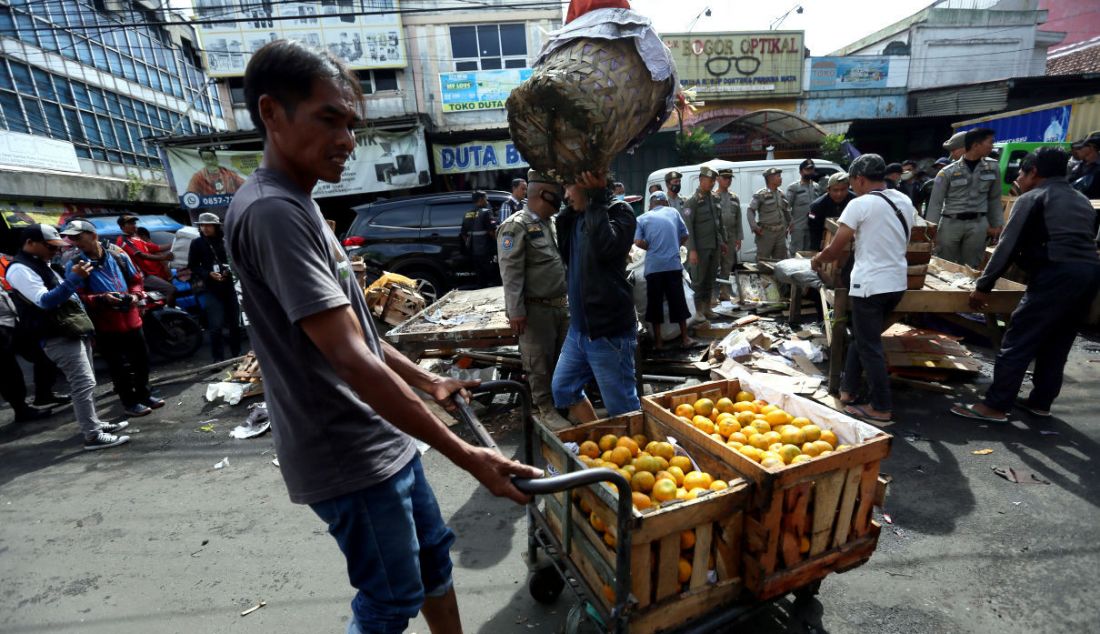 Petugas gabungan membongkar lapak PKL di Jalan Dewi Sartika, Kota Bogor, Jawa Barat, Selasa (24/1). Pembongkaran ratusan lapak PKL yang mengganggu ketertiban umum merupakan target Pemerintah Kota Bogor dalam penataan kawasan kota. - JPNN.com