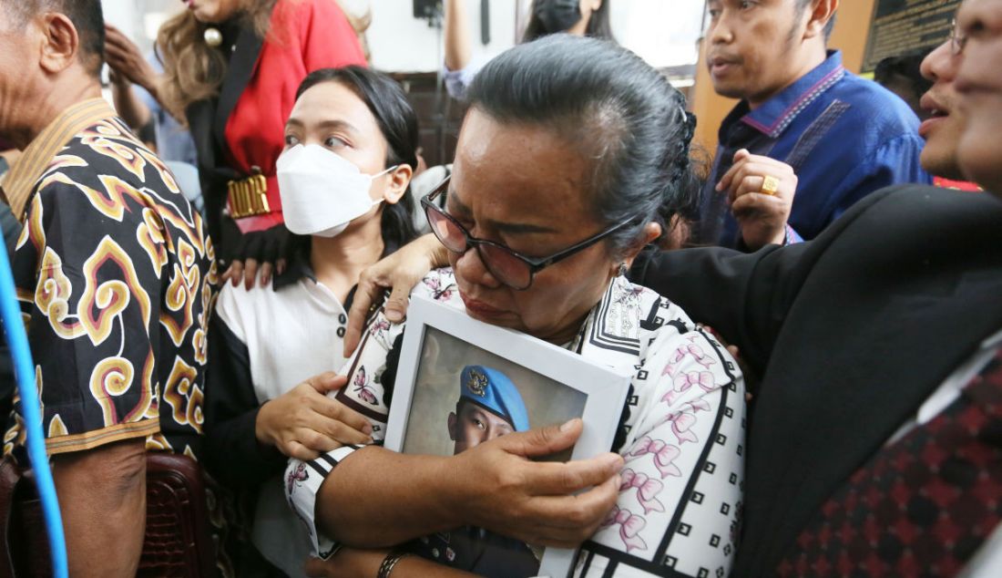 Rosti Simanjuntak memeluk foto anaknya saat menghadiri sidang putusan dengan terdakwa kasus pembunuhan Brigadir J, Richard Eliezer di Pengadilan Negeri Jakarta Selatan, Jakarta, Rabu (15/2). Richard Eliezer atau Bharada E divonis satu tahun dan enam bulan penjara. - JPNN.com