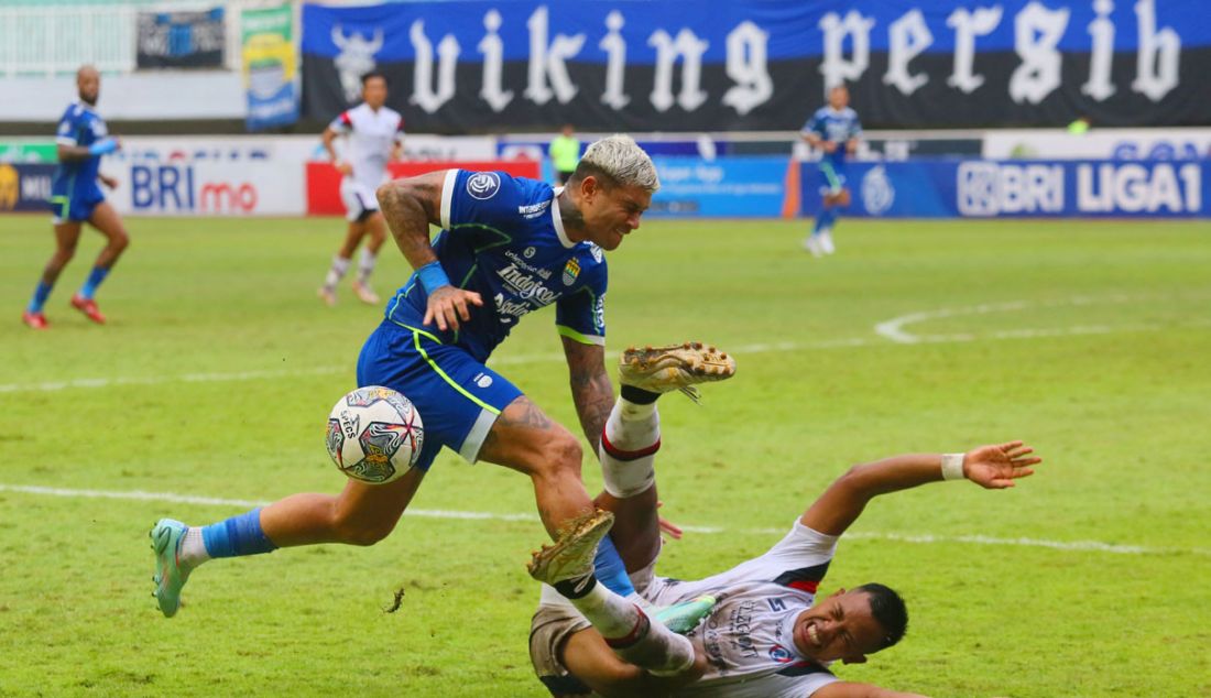 Penyerang Persib Bandung Ciro Alves (biru) berebut bola dengan bek Arema FC Joko Susilo dalam pertandingan Liga 1 di Stadion Pakansari, Kabupaten Bogor, Jawa Barat, Kamis (23/2). Persib Bandung mengalahkan Arema FC 1-0. - JPNN.com