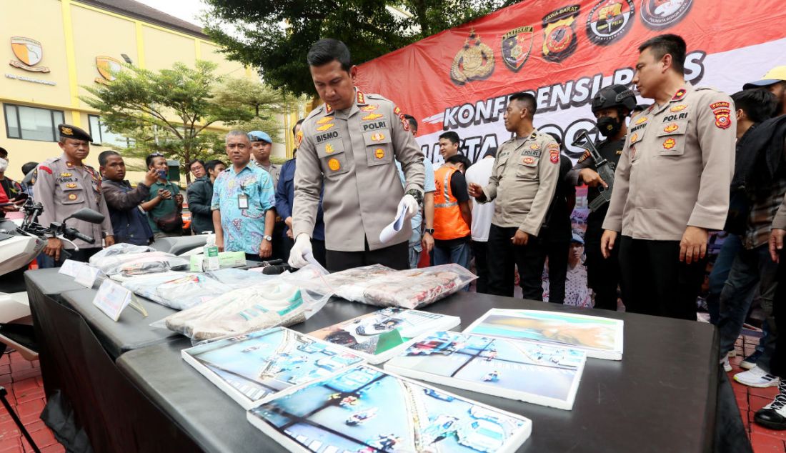 Kapolresta Bogor Kota Kombes Bismo Teguh Prakoso menunjukkan barang bukti golok gobang saat rilis kasus pembacokan pelajar di lampu merah Pomad Bogor Utara di Mako Polresta Bogor Kota, Kota Bogor, Selasa (14/3). Petugas mengamankan tiga tersangka bersama sejumlah barang bukti seperti golok gobang, HP tersangka, pakaian korban dan Honda PCX warna putih. Petugas masih memburu tersangka utama pembacok korban. - JPNN.com