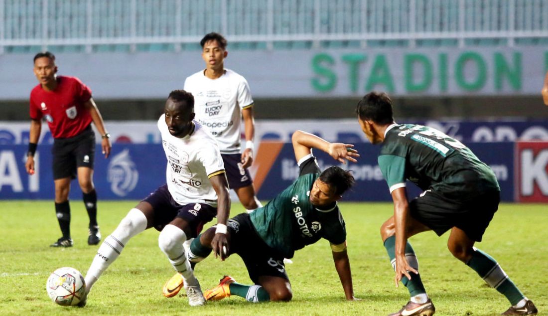 Pemain Rans Nusantara FC Makan Konate (putih) berusaha mempertahankan bola dari penjagaan pemain Persikabo 1973 Manahati Lestusen. - JPNN.com