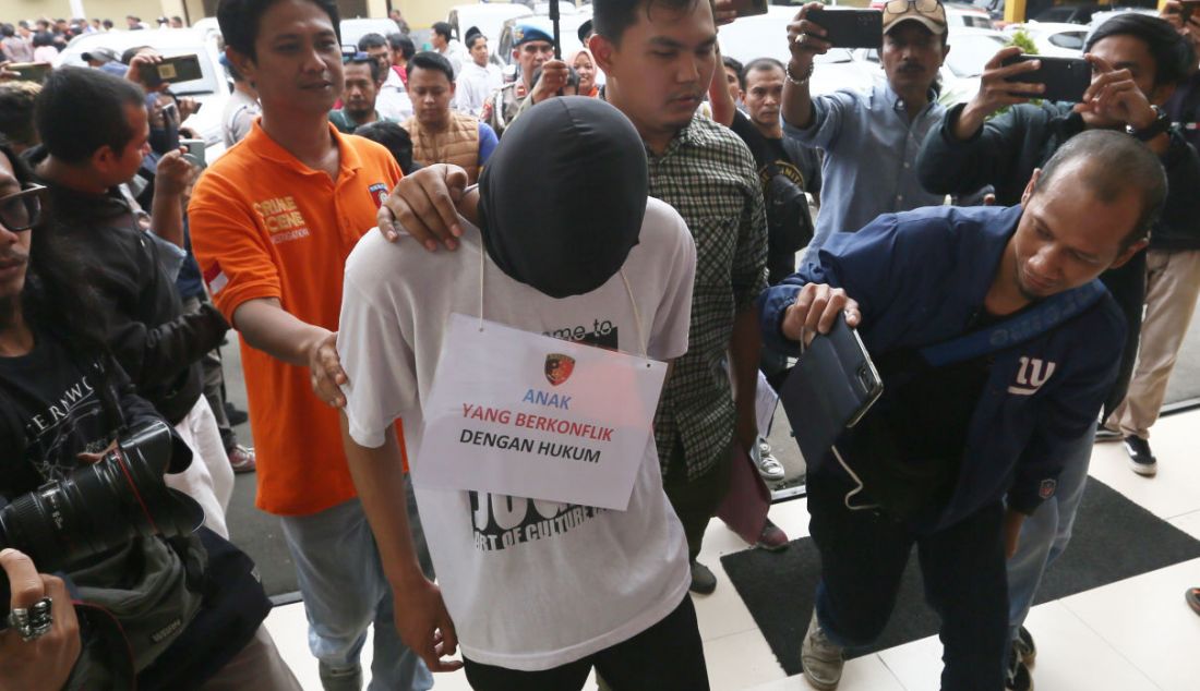 Petugas menggiring pelaku saat rilis kasus pembacokan pelajar di lampu merah Pomad Bogor Utara di Mako Polresta Bogor Kota, Kota Bogor, Selasa (14/3). - JPNN.com