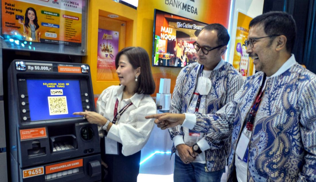 Kiri: Wakil Direktur Utama Bank Mega Diza Larentie, Deputi Direktur DKSP BI Arya Rangga Yogasati dan Direktur Executive ASPI Djamin Naenggolan mencoba fasilitas QRIS di ATM Bank Mega di sela-sela acara Festival Ekonomi Keuangan Digital Indonesia (FEKDI) 2023 di Jakarta, Minggu (7/5). Dalam upaya mewujudkan ekonomi digital, Bank Mega melalui aplikasi M-Smile juga telah siap untuk melengkapi fiturnya dengan QRIS TUNTAS (Transfer, Tarik Tunai dan Setor Tunai), sebagai pengembangan fitur terbaru dari QRIS sehingga dapat diandalkan pengguna untuk melakukan transaksi keuangan secara digital. - JPNN.com