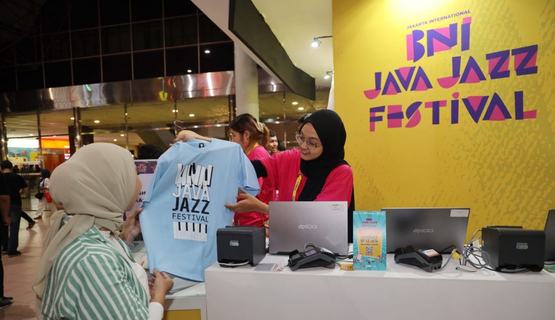 Salah satu pengunjung berminat membeli merchandise BNI Java Jazz Festival 2023, berupa kaus. Gelaran BNI Java Jazz Festival 2023 mendorong geliat konsumsi. - JPNN.com