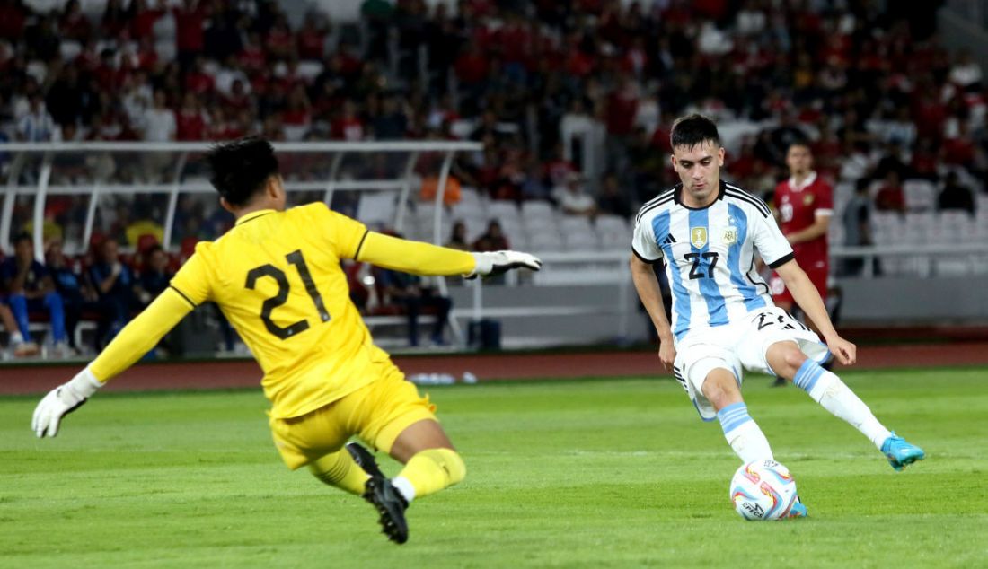 Pemain Timnas Argentina Facundo Valentin Buonanotte berusaha melewati kiper Timnas Indonesia Ernando Ari Sutaryadi pada FIFA Match day Indonesia melawan Argentina di SUGBK, Jakarta, Senin (19/6). Argentina menang atas Indonesia dengan skor 2-0. - JPNN.com