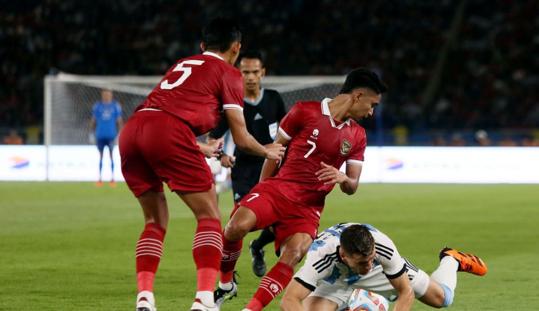 Pemain Timnas Argentina Giovani Lo Celso terjatuh setelah dihadang dua pemain Timnas Indonesia pada FIFA Match day Indonesia melawan Argentina di SUGBK, Jakarta, Senin (19/6). Argentina menang atas Indonesia dengan skor 2-0. - JPNN.com