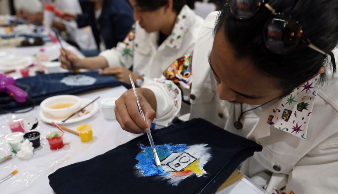 Pengunjung melukis di celana panjang jin dalam talkshow Emba Jeans x Monez Hadirkan Kolaborasi Dengan Sentuhan Inspirasi Modern Pop Art di Gedung Sarinah, Thamrin, Jakarta, Sabtu (1/7). - JPNN.com
