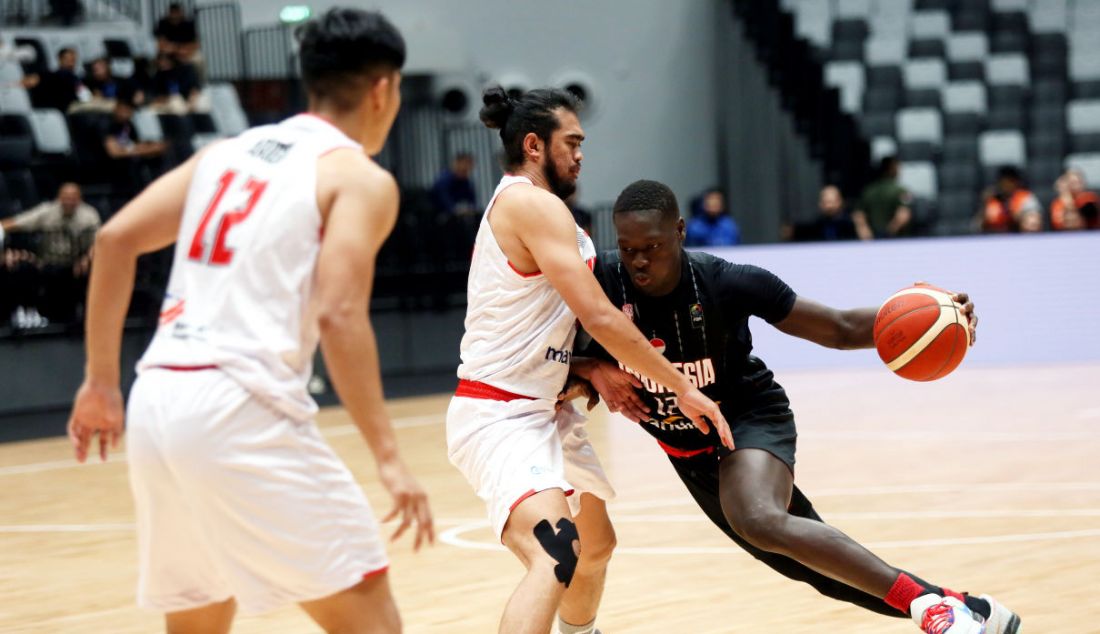 Pebasket Indonesia Patriot Dame Diagne (kanan) berusaha melewati hadangan pebasket Timnas Indonesia Muhammad Reza Fahdani Guntara dalam laga Indonesia International Basketball Invitational (IIBI) 2023 di Indonesia Arena, Senayan, Jakarta, Rabu (2/8). Timnas basket Indonesia menang atas Indonesia Patriots dengan skor akhir 82-56. - JPNN.com