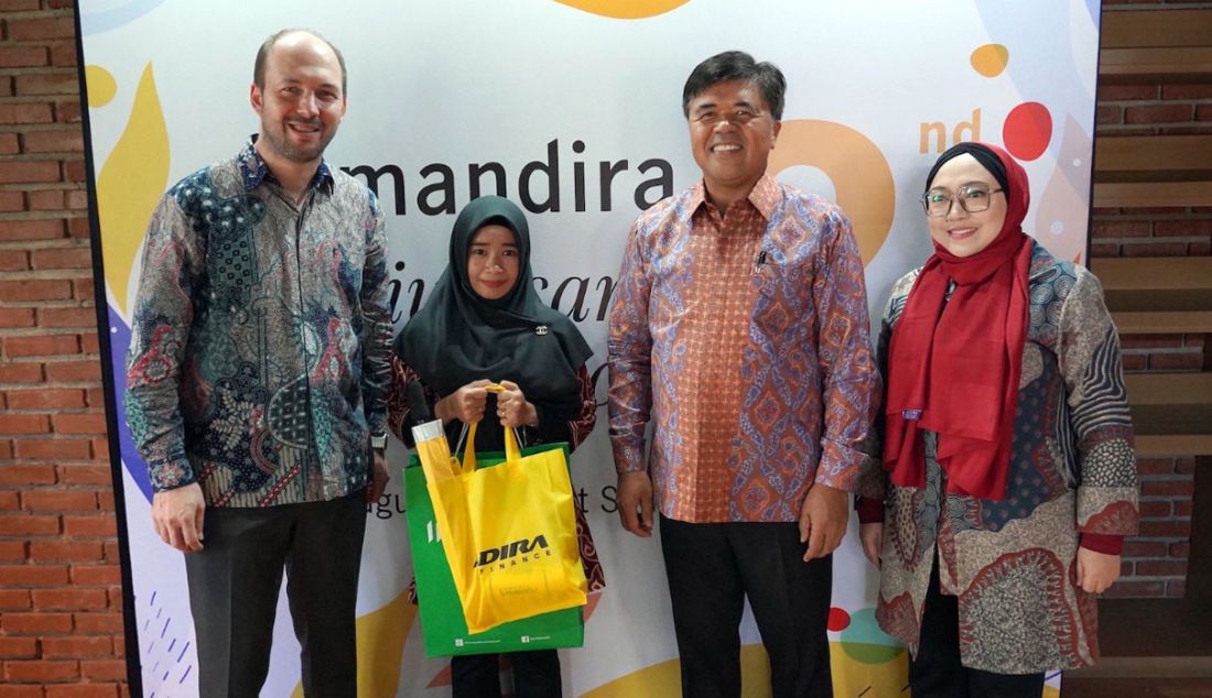 Presiden Direktur & CEO Manulife Indonesia Ryan Charland (kiri) dan Direktur Utama Adira Finance Dewa Made Susila (kedua dari kanan) memberikan tanda mata kepada perwakilan ahli waris nasabah Amandira Irma Liesti (kedua dari kiri) di Jakarta, Rabu (9/8). Irma telah menerima klaim Amandira senilai Rp10.000.000 dan apresiasi ini merupakan salah satu wujud nyata komitmen Manulife Indonesia dan Adira Finance untuk melindungi nasabahnya. - JPNN.com