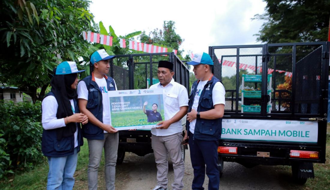 BSI dan BSI Maslahat bersama Relawan Bakti BUMN memberikan bantuan Bank Sampah Mobile kepada Kepala Desa Meunasah Asan Bachtiar (kanan kedua) sebagai bentuk kepedulian lingkungan di Desa Muenasah Asan, Aceh Timur. Selain itu masyarakat diajarkan pula bagaimana mengelola dan memilah sampah plastik. - JPNN.com