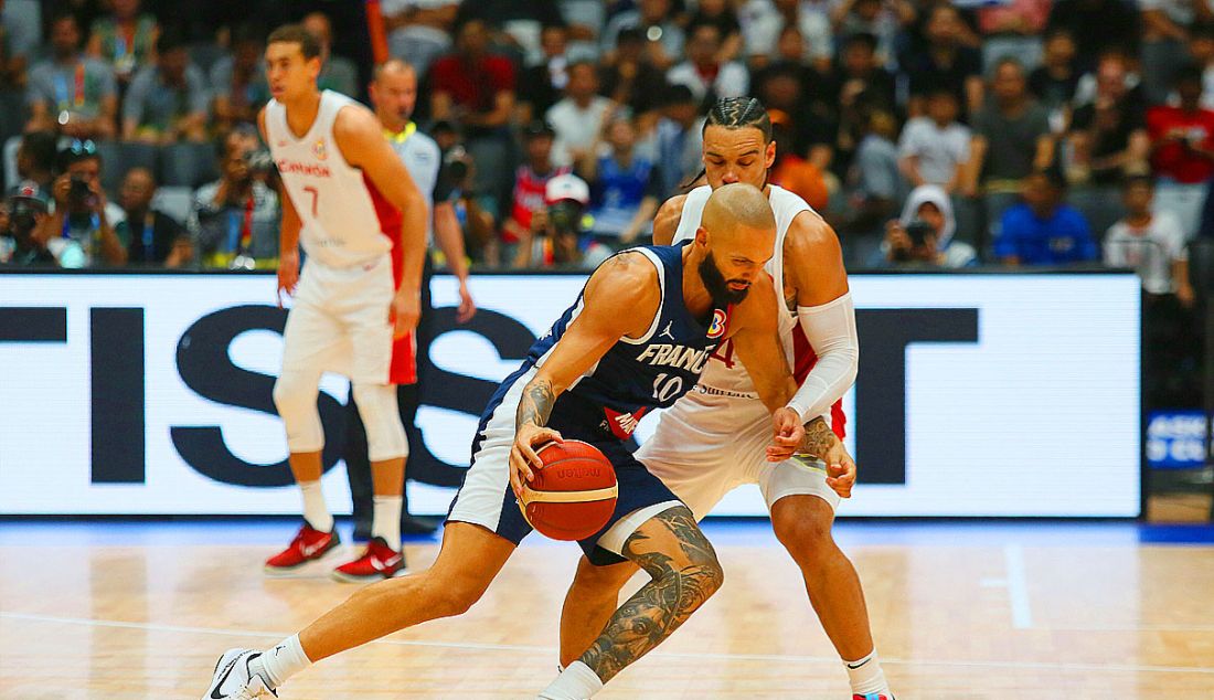 Pebasket Prancis Evan Fournier (biru) saat diadang pebasket Kanada Dillon Brooks dalam laga babak fase grup FIBA World Cup 2023 antara Prancis melawan Kanada, di Jakarta, Jumat (25/8). Kanada menang atas Prancis dengan skor 95-65. - JPNN.com