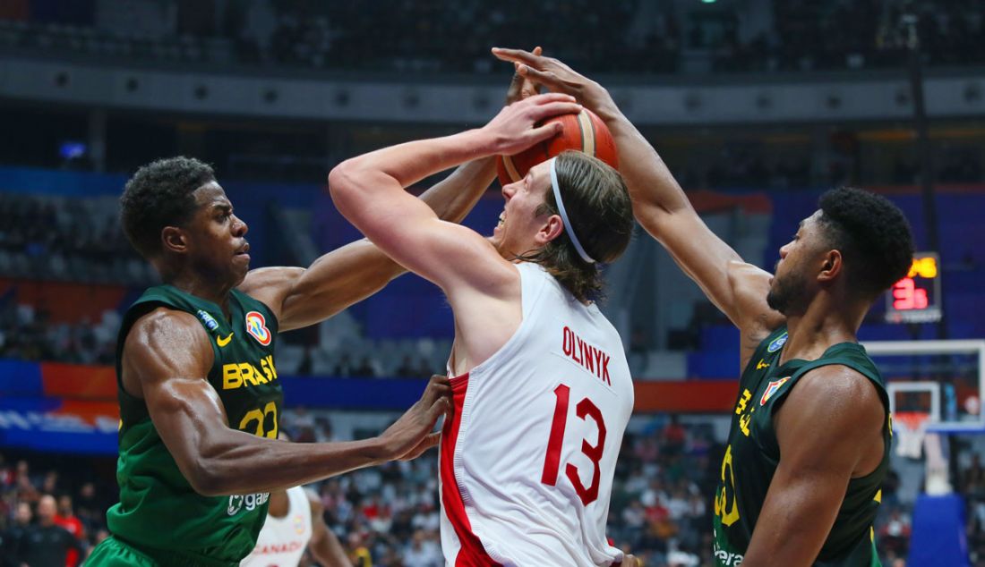 Dua pebasket Brasil saat mengadang pebasket Kanada Kelly Olynyk pada putaran kedua Grup L FIBA World Cup 2023 di Indonesia Arena, Gelora Bung Karno, Senayan, Jakarta, Jumat (1/9). Brasil berhasil mengalahkan Kanada dengan skor 69-65. - JPNN.com