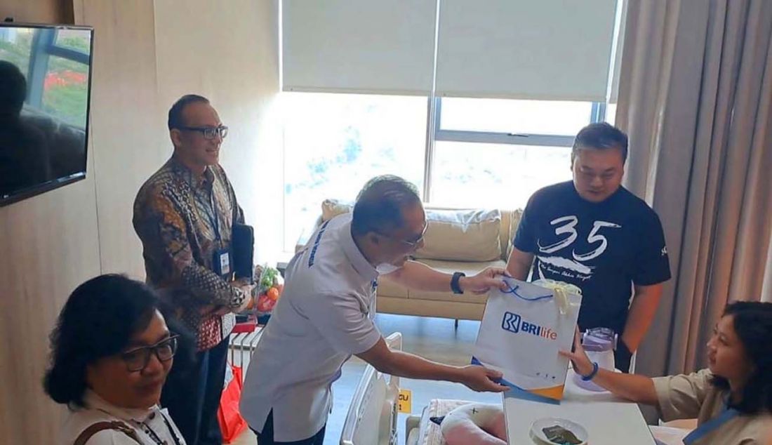 Direktur Utama BRI Life Iwan Pasila (tengah) memberikan bingkisan kepada pasien nasabah BRI Life di Rumah Sakit Eka Hospital Cibubur, Jakarta, Senin (4/9). - JPNN.com