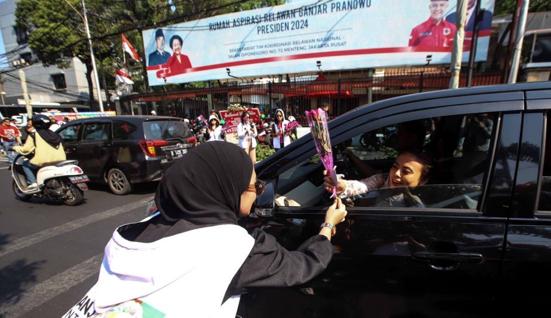 Sukarelawan membagikan bunga mawar kepada pengendara, Jakarta, Sabtu (28/10). Kegiatan yang diselenggarakan oleh nakes yang terdiri dari dokter dan perawat ini dalam merayakan ulang tahun ke-55 Ganjar Pranowo. - JPNN.com