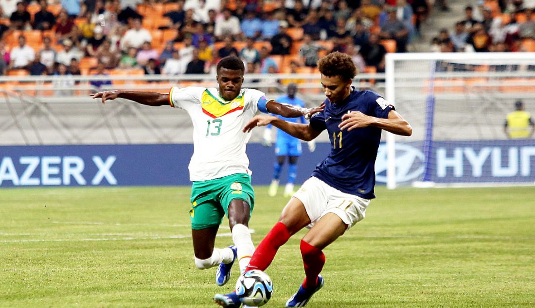 Pesepak bola Timnas U17 Prancis Gomis Tidiam (kanan) berduel pesepak bola Timnas U17 Senegal Toure Alpha pada pertandingan perdelapan final Piala Dunia U-17 2023 di Stadion JIS, Jakarta, Rabu (22/11). Prancis menang atas Senegal dalam adu penalti dengan skor 5-3. - JPNN.com