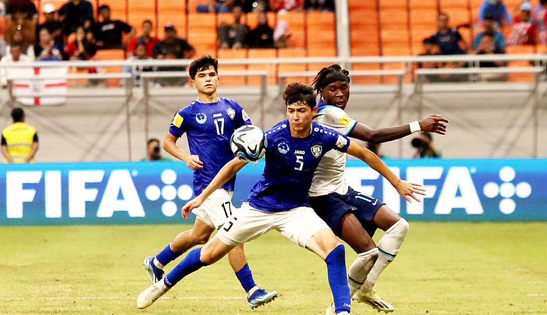 Pesepak bola Timnas U17 Uzbekistan Tulkunbekov Azizbek saat berduel pesepak bola Timnas U17 Inggris Ndala Joel pada pertandingan babak perdelapan final Piala Dunia U-17 2023 di Stadion JIS, Jakarta, Rabu (22/11). Timnas U17 Uzbekistan menang atas Timnas U17 Inggris dengan skor 2-1. - JPNN.com