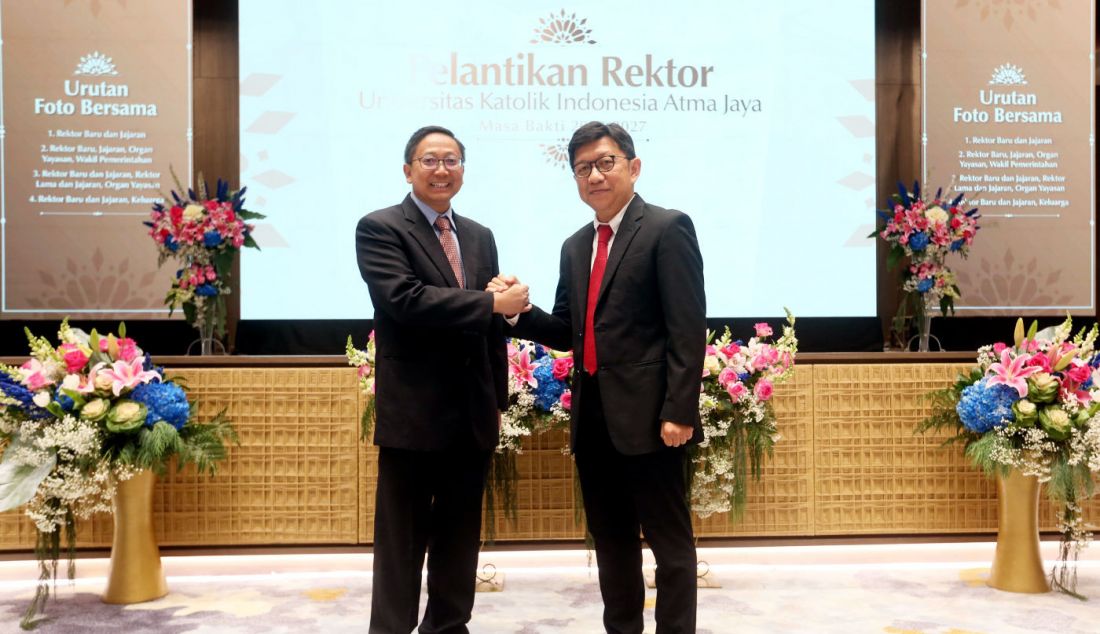 Rektor Unika Atma Jaya 2023-2027 Yuda Turana (kanan) salam komando dengan pendahulunya, Agustinus Prasetyantoko. - JPNN.com