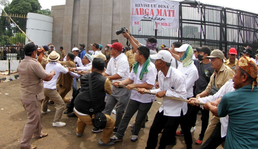 Massa dari Asosiasi Pemerintah Desa Seluruh Indonesia (APDESI) melakukan aksi demonstrasi di depan Gedung Parlemen MPR/DPR-DPD, Senayan, Jakarta, Rabu (31/1). Dalam aksi yang ketiga kalinya ini, meraka menuntut agar DPR sagera mengesahkan Revisi UU Desa. Selama aksi para kepala desa ini juga melakukan bakar ban didepan gerbang sebagai bentuk protes agar DPR mendengarkan apresiasi Merdeka. - JPNN.com