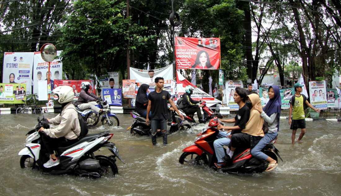 Pengendara mendorong motornya saat melintas di Jalan Pusdiklat Depnaker, Makasar, Jakarta Timur, Rabu (31/1). Hujan deras yang melanda Jakarta sejak Rabu malam (31/1) menyebabkan Jalan Pusdiklat Depnaker, Kecamatan Makasar Jakarta Timur terendam banjir. - JPNN.com