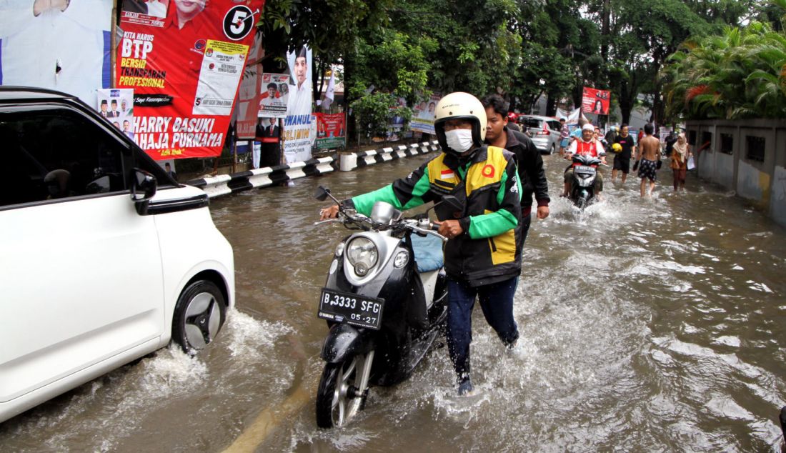 Pengendara mendorong motornya saat melintas di Jalan Pusdiklat Depnaker, Makasar, Jakarta Timur, Rabu (31/1). Hujan deras yang melanda Jakarta sejak Rabu malam (31/1) menyebabkan Jalan Pusdiklat Depnaker, Kecamatan Makasar Jakarta Timur terendam banjir. - JPNN.com