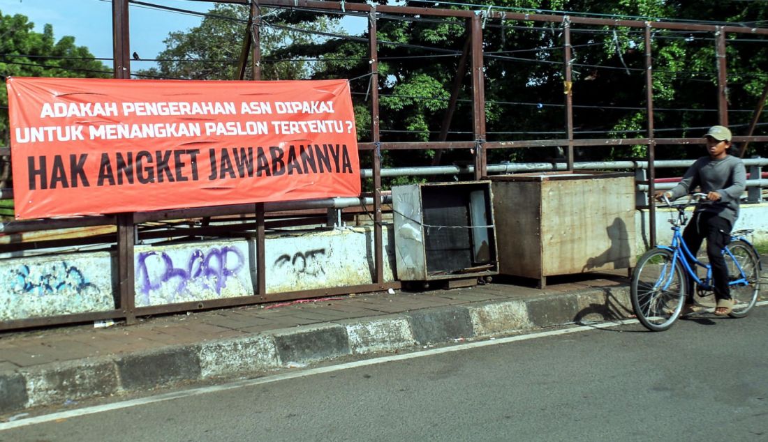 Warga melintas di depan spanduk bertuliskan Hak Angket Jawabannya, di Jakarta, Jumat (1/3). - JPNN.com