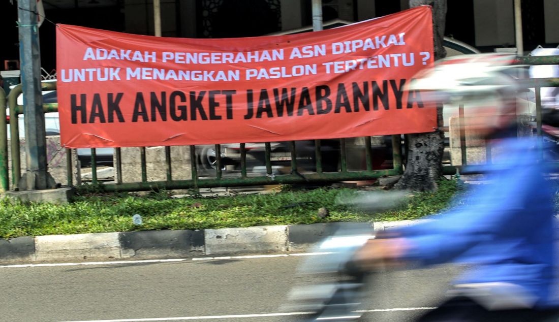 Warga melintas di depan spanduk bertuliskan Hak Angket Jawabannya, di Jakarta, Jumat (1/3). - JPNN.com