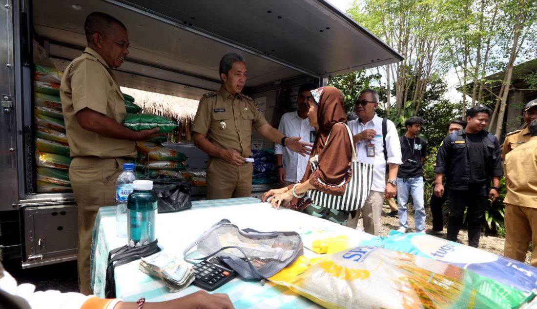 Wakil Wali Kota Bogor Dedie A. Rachim menyerahkan beras seharga Rp 53 ribu/5 kg saat kegiatan Operasi Pasar Bulog Siaga di kawasan Mulyaharja, Bogor, Senin (4/3). - JPNN.com