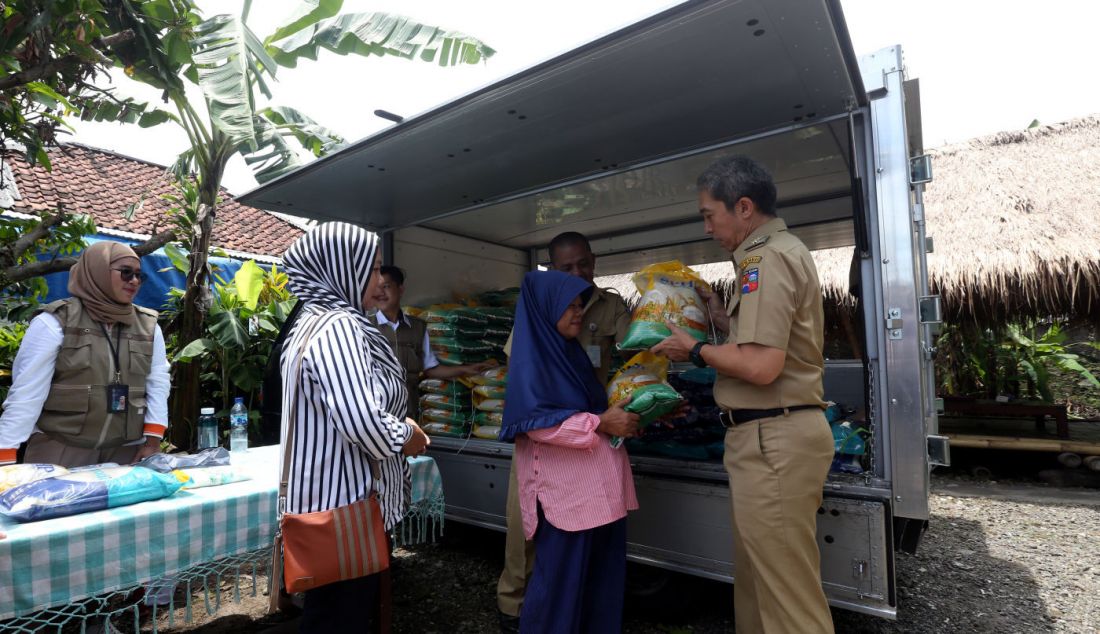 Wakil Wali Kota Bogor Dedie A. Rachim menyerahkan beras seharga Rp 53 ribu/5 kg saat kegiatan Operasi Pasar Bulog Siaga di kawasan Mulyaharja, Bogor, Senin (4/3). - JPNN.com
