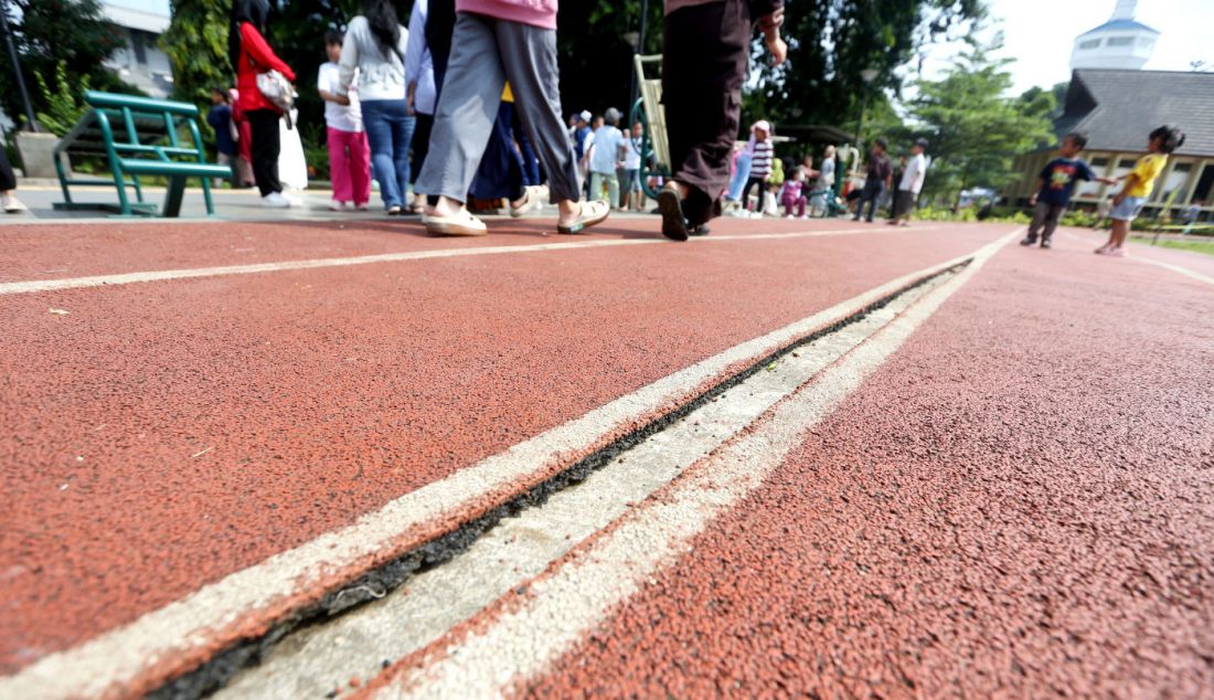 Warga saat berjalan di area jogging track Alun-alun Kota Bogor, Jawa Barat, Selasa (16/4). Beberapa Area jogging track tersebut mengalami kerusakan seperti robek dan gompang. - JPNN.com