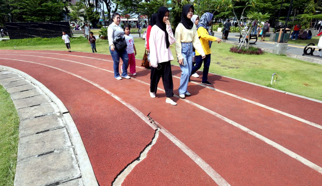 Warga saat berjalan di area jogging track Alun-alun Kota Bogor, Jawa Barat, Selasa (16/4). Beberapa Area jogging track tersebut mengalami kerusakan seperti robek dan gompang. - JPNN.com