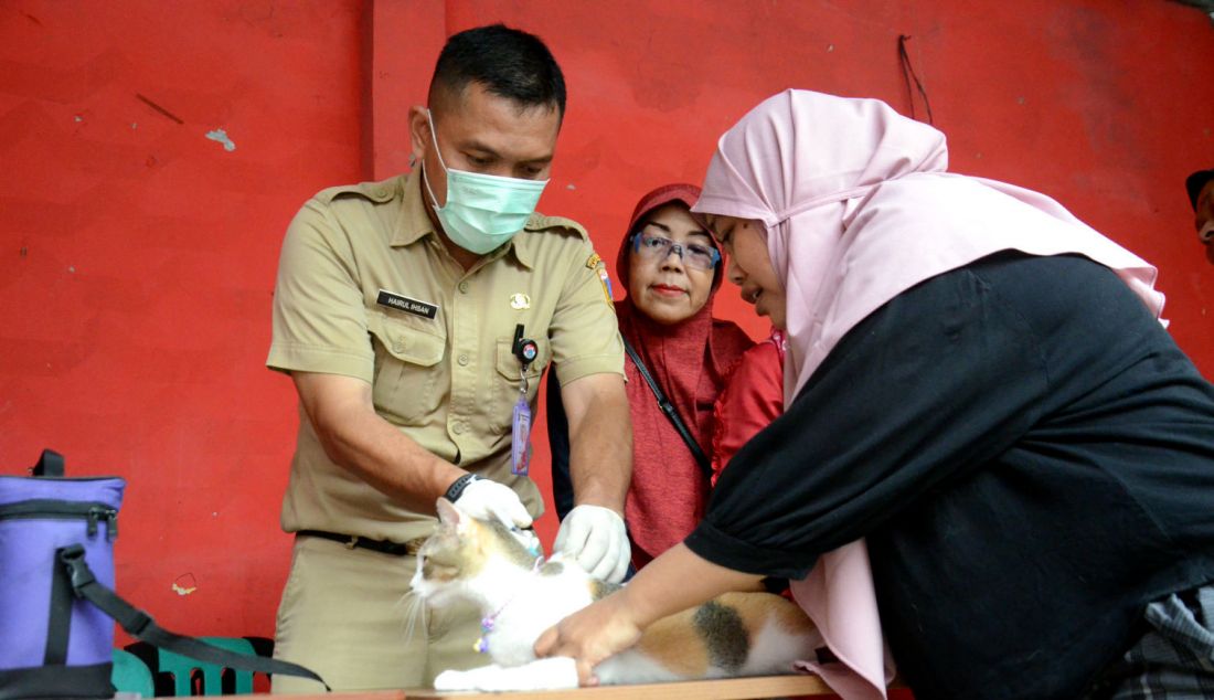 Plh. Kasatpel Ketahanan Pangan Kelautan dan Pertanian Kecamatan Tebet Ikhsan melakukan vaksinasi rabies gratis hewan peliharaan di Balai warga RW 10, Perintis, Kebon Baru, Jakarta Selatan, Senin (14/5). Hewan-hewan yang menjadi sasaran vaksinasi antara lain anjing, kucing, kera, dan musang. - JPNN.com