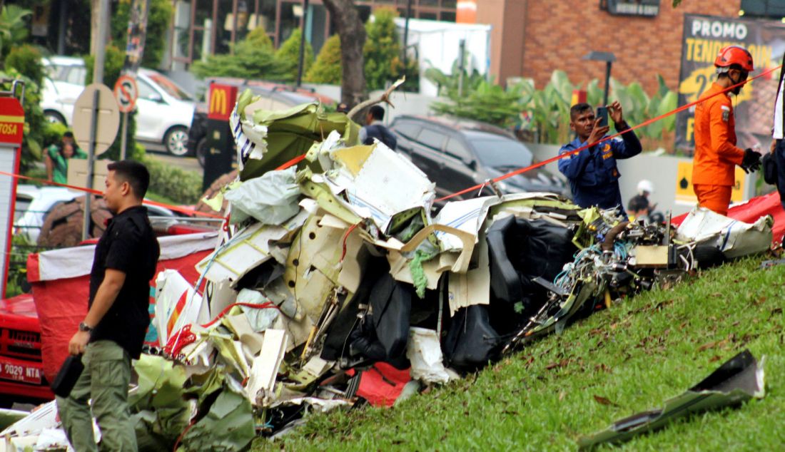 Sejumlah petugas gabungan mengevakuasi pesawat latih Cessna 2006 dengan nomor registrasi PK-IFP milik Indonesia Flying Club (Perkumpulan Penerbang Indonesia) di kawasan BSD, Tangerang Selatan, Banten, Minggu (19/5). Dilaporkan tiga orang korban meninggal dunia atas insiden tersebut. - JPNN.com